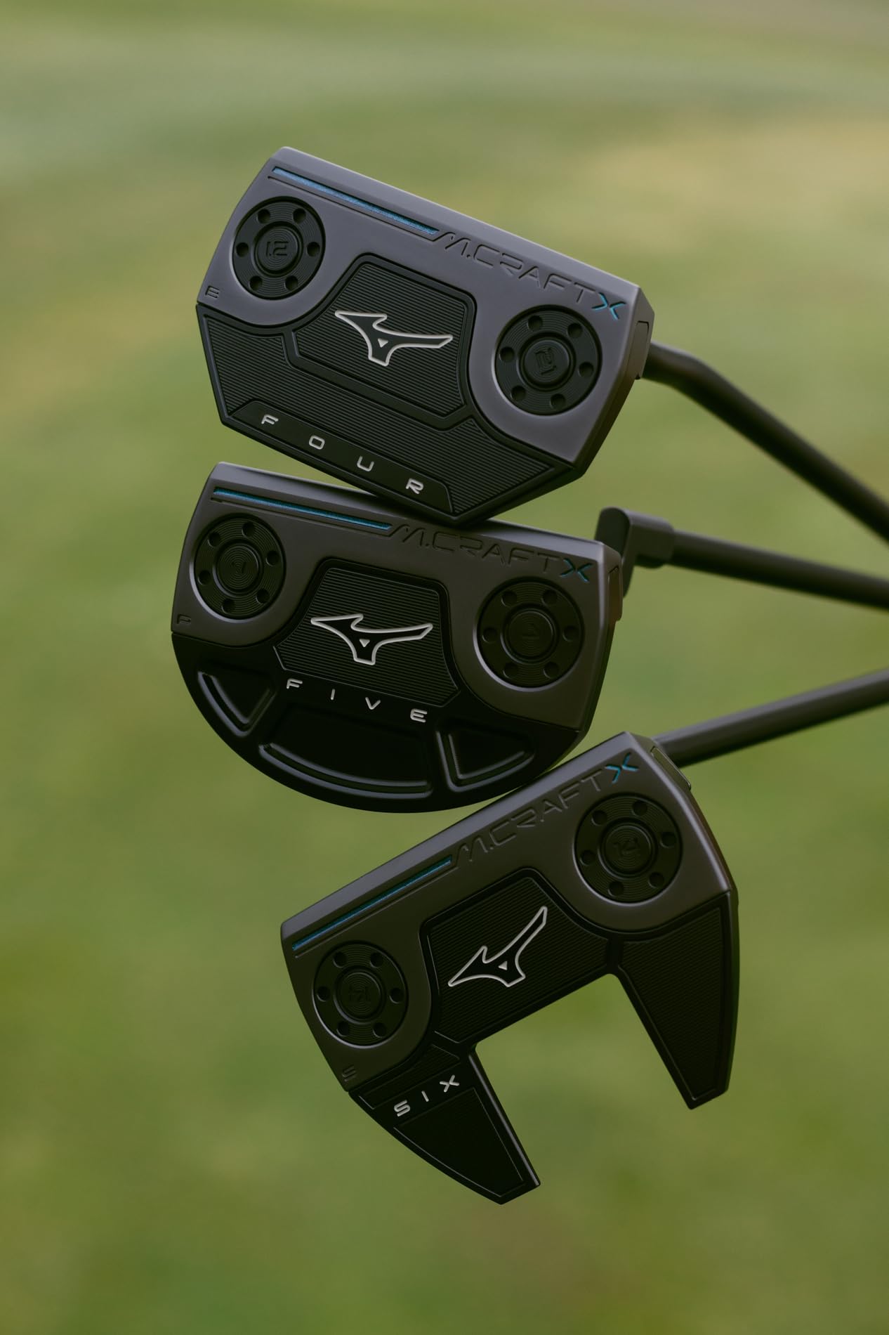 Lifestyle image of three Mizuno M Craft X Putters over a golf green