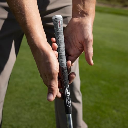 Close-up of hands holding a golf club on a grassy background
