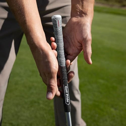 Close-up of hands holding a golf club on a grassy background