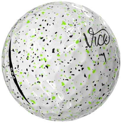 White golf ball with green and black speckles and 'Vice' branding on a white background