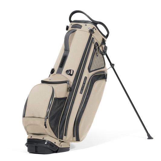 Beige and black golf bag with a stand on a white background