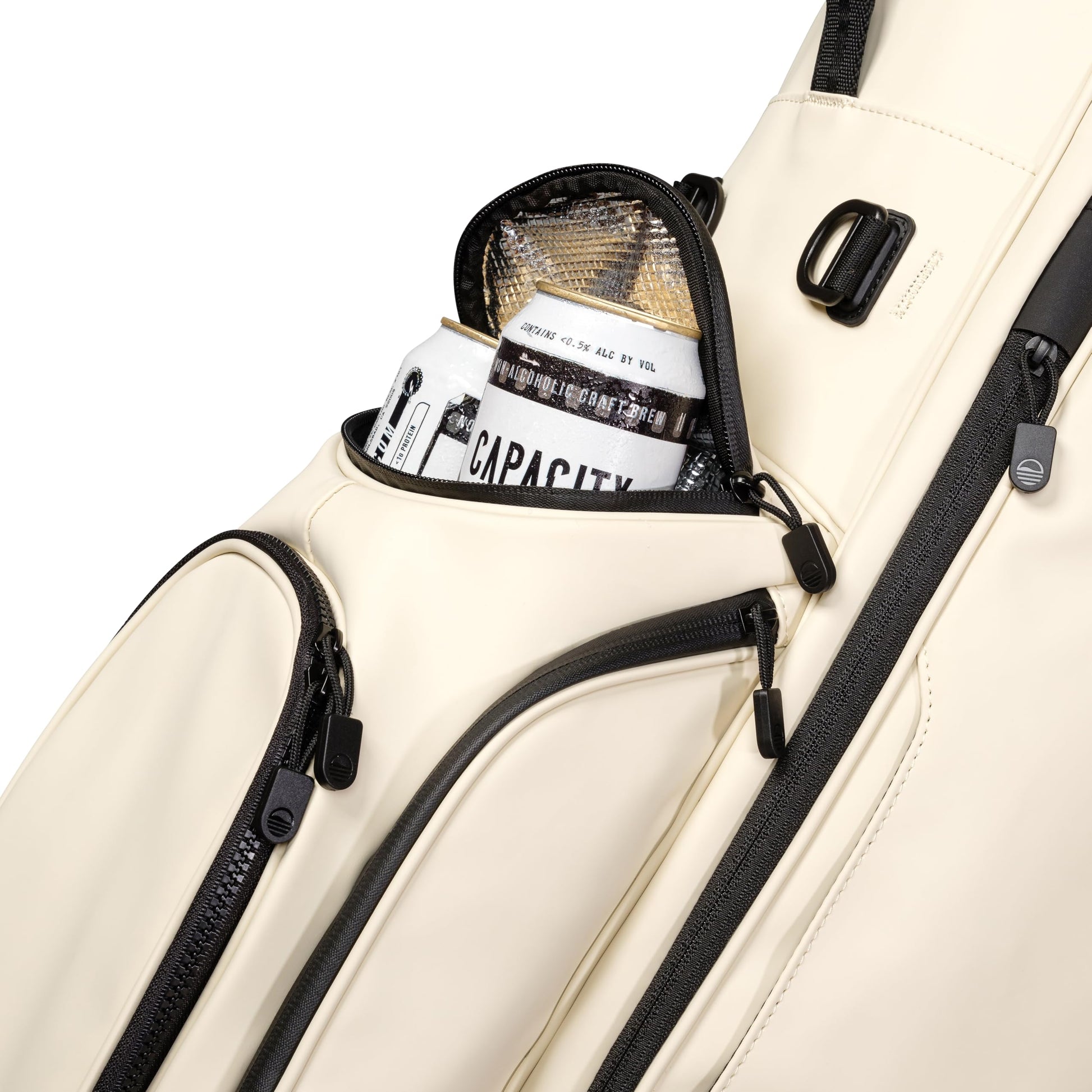 Beige golf bag with black zippers and a can of coffee inside, on a white background