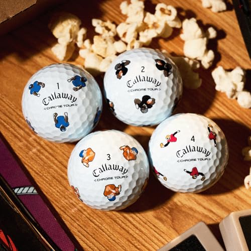 Four Callaway golf balls with cartoon characters on a wooden surface with popcorn.