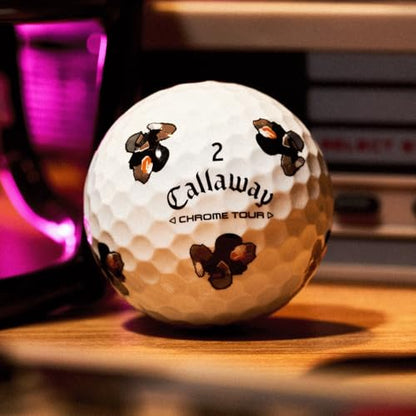 Callaway golf ball with bee designs on a wooden surface