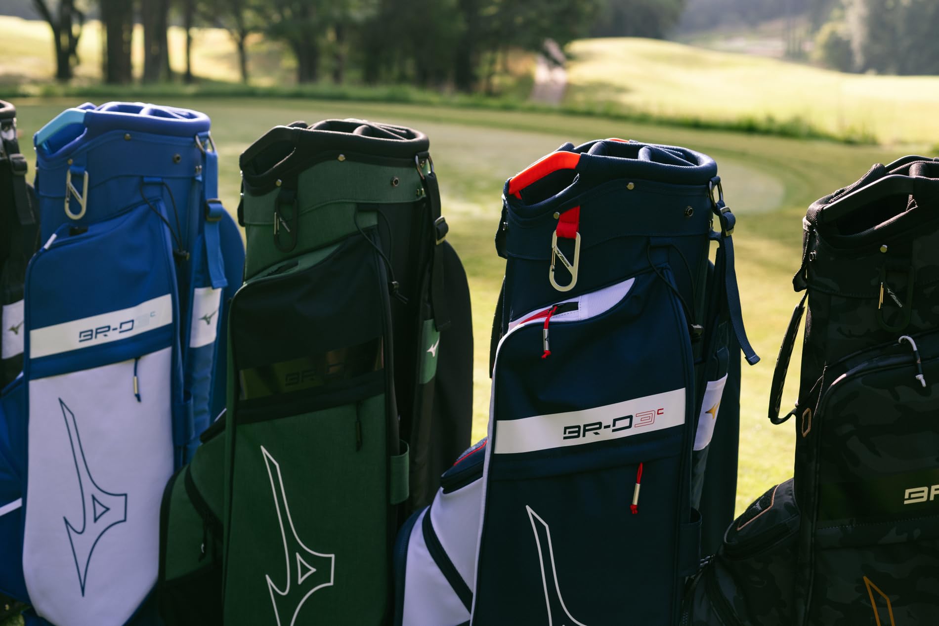 Four golf bags with visible branding on a grassy background